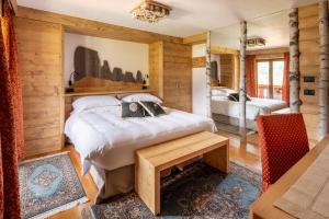 ein Schlafzimmer mit einem Bett und einem Tisch in einem Zimmer in der Unterkunft Hotel Columbia & Spa in Cortina d'Ampezzo