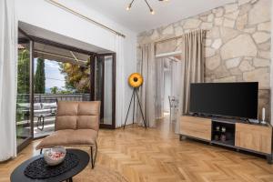 a living room with a flat screen tv and a couch at Apartments Carmen in Matulji