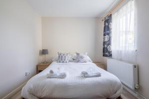 a bedroom with a white bed with towels on it at Comfy Central Apartment in Cambridge in Cambridge