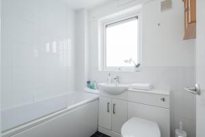 a white bathroom with a sink and a toilet at Comfy Central Apartment in Cambridge in Cambridge