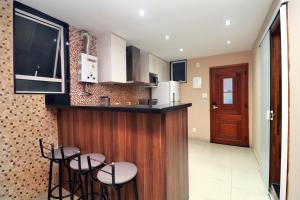 a kitchen with a bar with stools and a tv at Rio Spot Homes Copacabana D038 in Rio de Janeiro