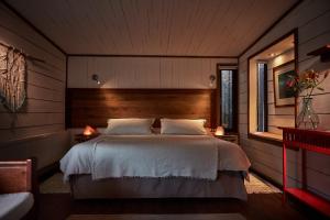 een slaapkamer met een groot bed en 2 lampen bij Cuarzo Lodge in Pichilemu