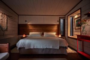 1 dormitorio con 1 cama grande y 2 lámparas en Cuarzo Lodge, en Pichilemu