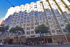 duży biały budynek z ludźmi stojącymi przed nim w obiekcie Rio Spot Homes Copacabana D038 w mieście Rio de Janeiro