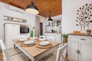 - une cuisine avec une table en bois et des placards blancs dans l'établissement Apartment Carmen, à Matulji