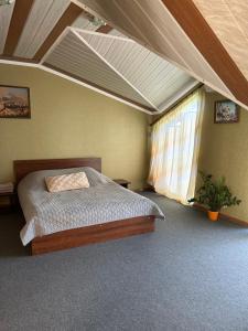 1 dormitorio con 1 cama y techo con ventana en Міні-готель, en Kotowsk