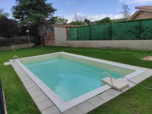 une grande piscine dans un jardin avec pelouse dans l'établissement EN EL CORAZON DEL BARRIO DE LA ESTACIÓN, à Haro