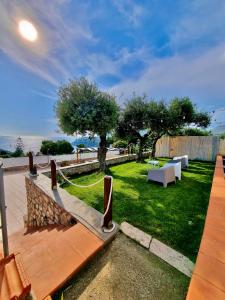 a backyard with a table and benches and the ocean at Acquamarina in Gaeta