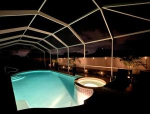a swimming pool with a roof at night at Villa Haze, Private Heated Pool & Spa, South Cape Coral in Cape Coral