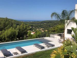 uma piscina com espreguiçadeiras ao lado de uma casa em Villa Contemporaine vue mer-vignobles,Piscine-Spa em Sanary-sur-Mer