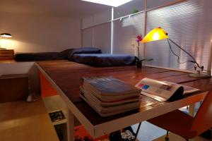 a living room with a desk with a lamp and books at Termini Loft in Rome