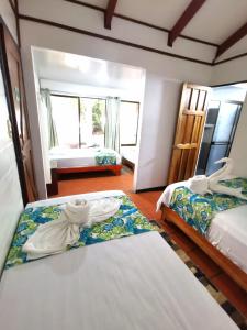 a hotel room with two beds with towels on them at Casa Marbella in Tortuguero