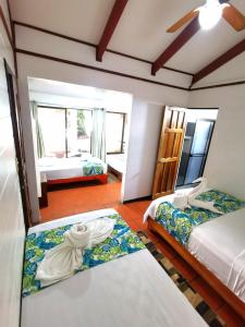 a hotel room with two beds and a bedroom with a view at Casa Marbella in Tortuguero