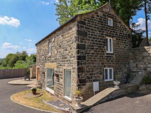 un edificio de ladrillo con dos ventanas laterales en Cunliffe Barn en Shipley