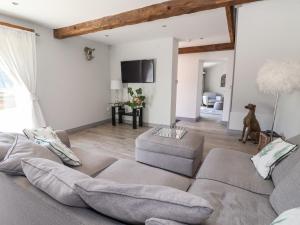 a living room with a couch and a tv at Cunliffe Barn in Shipley