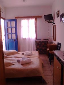 a hotel room with two beds and a window at Karagiannaki in Skála Sykaminéas