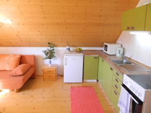 una piccola cucina con frigorifero e divano di Chalupa u Lipna a Nová Pec