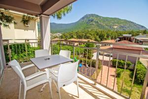 d'un balcon avec une table, des chaises et une montagne. dans l'établissement Nokta Kaya Suit Apart, Fethiye, Ölüdeniz, à Fethiye