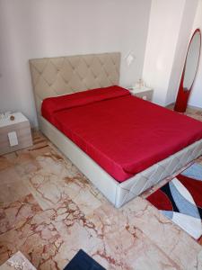 a bedroom with a bed with a red bedspread at PAIPER B&B in Palermo