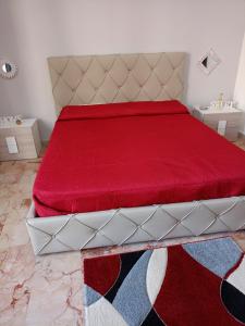 a bedroom with a bed with a red bedspread at PAIPER B&B in Palermo