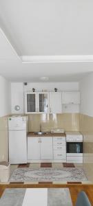 a kitchen with white cabinets and a sink at Apartman NM in Foča