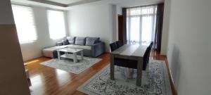 a living room with a table and a couch at Apartman NM in Foča