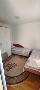 um quarto com duas camas e um tapete em Apartman NM em Foca