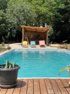 a swimming pool with chairs and a gazebo at Chambre d'hôtes Les Cyprès de l'île in Avignon