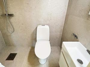a bathroom with a white toilet and a sink at Holiday home Sölvesborg XII in Sölvesborg