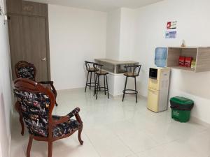 a room with a chair and a table and a counter at Hotel Monaco in Tuluá