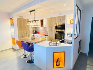 a kitchen with a counter and chairs in it at #Sète T3 Vue mer & étang Piscine Balcon in Sète