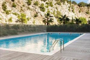 a swimming pool with a mountain in the background at Luxueux T3 Piscine et Vue Somptueuse in Sète