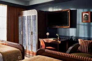 a hotel room with a desk and a tv at The Manchester Hotel in Lexington