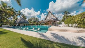 a swimming pool with lounge chairs and a resort at Luxury Beach Apartment at El Portillo - no extra fees in Las Terrenas