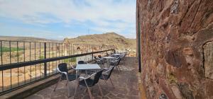 Castillo de Illueca في Illueca: مجموعة طاولات وكراسي على شرفة