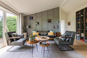 a living room with two couches and a table at NOFLIK, een gezellig chalet met een fraaie en rustige ligging in Stegeren