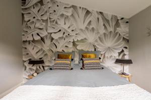 StegerenにあるNOFLIK, een gezellig chalet met een fraaie en rustige liggingのベッドルーム1室(ベッド1台付)、花の壁