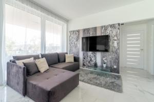 a living room with a couch and a flat screen tv at Luxury Apartman SPA Residence Hévíz in Hévíz