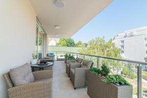 a balcony with couches and a table and chairs at Luxury Apartman SPA Residence Hévíz in Hévíz