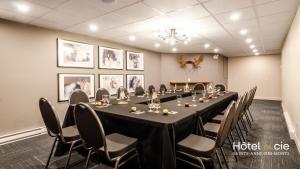 a conference room with a long table and chairs at Hôtel & cie in Sainte-Anne-des-Monts