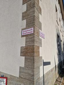 un letrero de la calle en el lateral de un edificio en Unterkunft Greifswald, en Greifswald