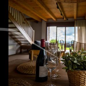 a bottle of wine and two glasses on a table at Les Casetes de Molló in Molló