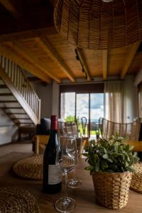 莫略的住宿－Les Casetes de Molló，桌子上放有一瓶葡萄酒和两杯酒