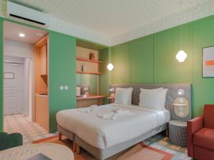 a bedroom with a bed and a green wall at Aparthotel AMMI Nice Lafayette in Nice