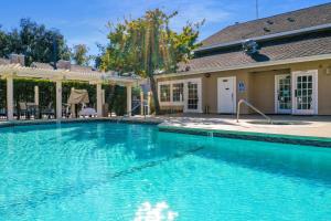 a large blue swimming pool in front of a house at Chase Suite Hotel Newark Fremont in Newark