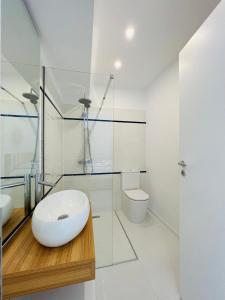 a white bathroom with a sink and a toilet at Oxygen Residence in Neptun