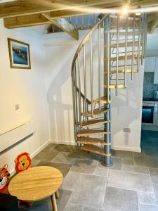 a spiral staircase in a room with a wooden table at Pixie Cottage in Stoborough