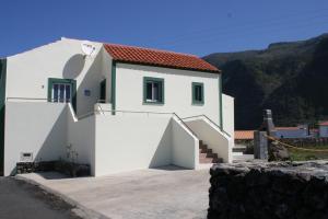 une maison blanche avec un escalier en face de celle-ci dans l'établissement Casa Fagundes, à Faja Grande