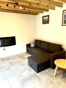 a living room with a couch and a flat screen tv at Pixie Cottage in Stoborough