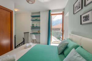 a bedroom with a green bed and a window at La Casa del Pescatore in Cernobbio